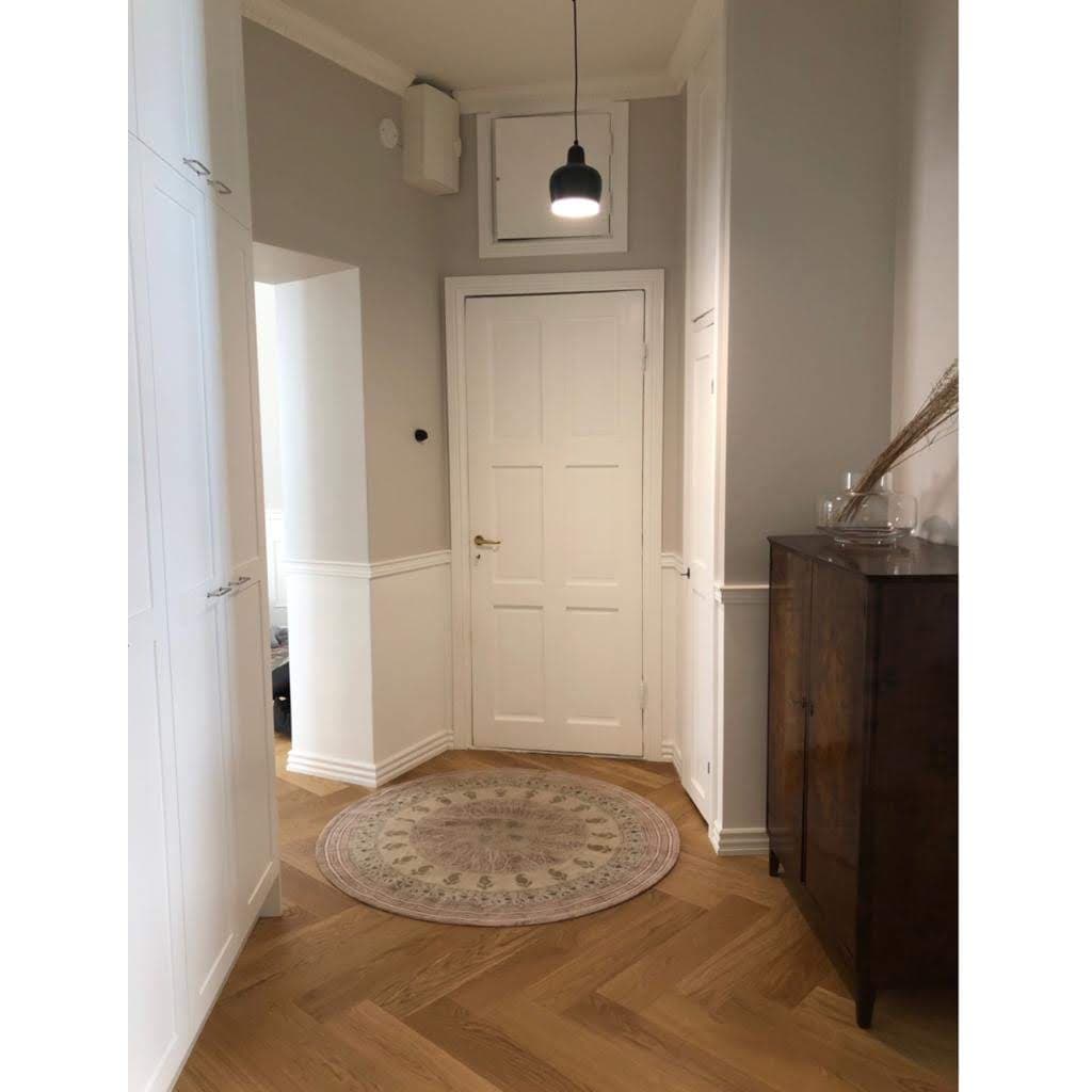 A powder room with marble-look tiling and brass fixtures, completed by Pohjola Constructions