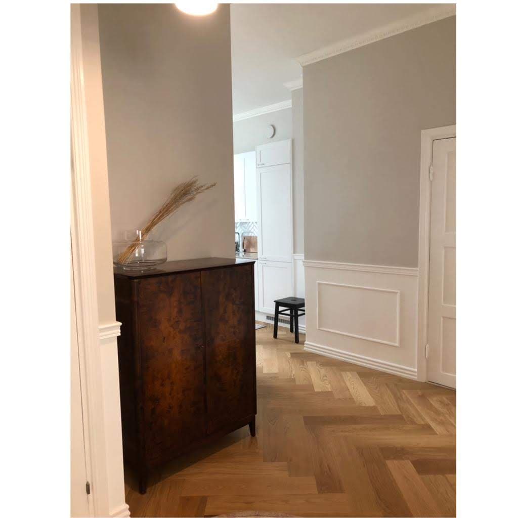 A heritage-style hallway with herringbone timber flooring and detailed wall panelling, from a completed Pohjola Constructions renovation